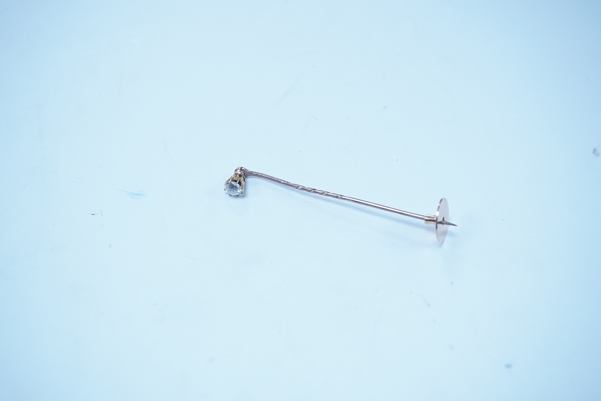 A yellow metal and solitaire diamond set stick pin, the stone diameter approx. 5mm, 59mm, gross weight 2.3 grams. Condition - fair to good